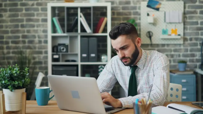 a man sitting in front of a laptop computer